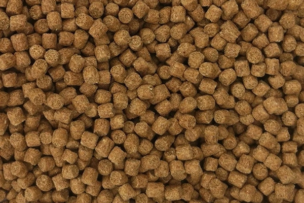 Primer_Plano_De_Pelets_Marrones_De_Alimento_Flotante_Para_Peces